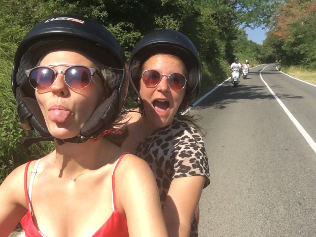 Two girls traveling with the vespa in tuscany