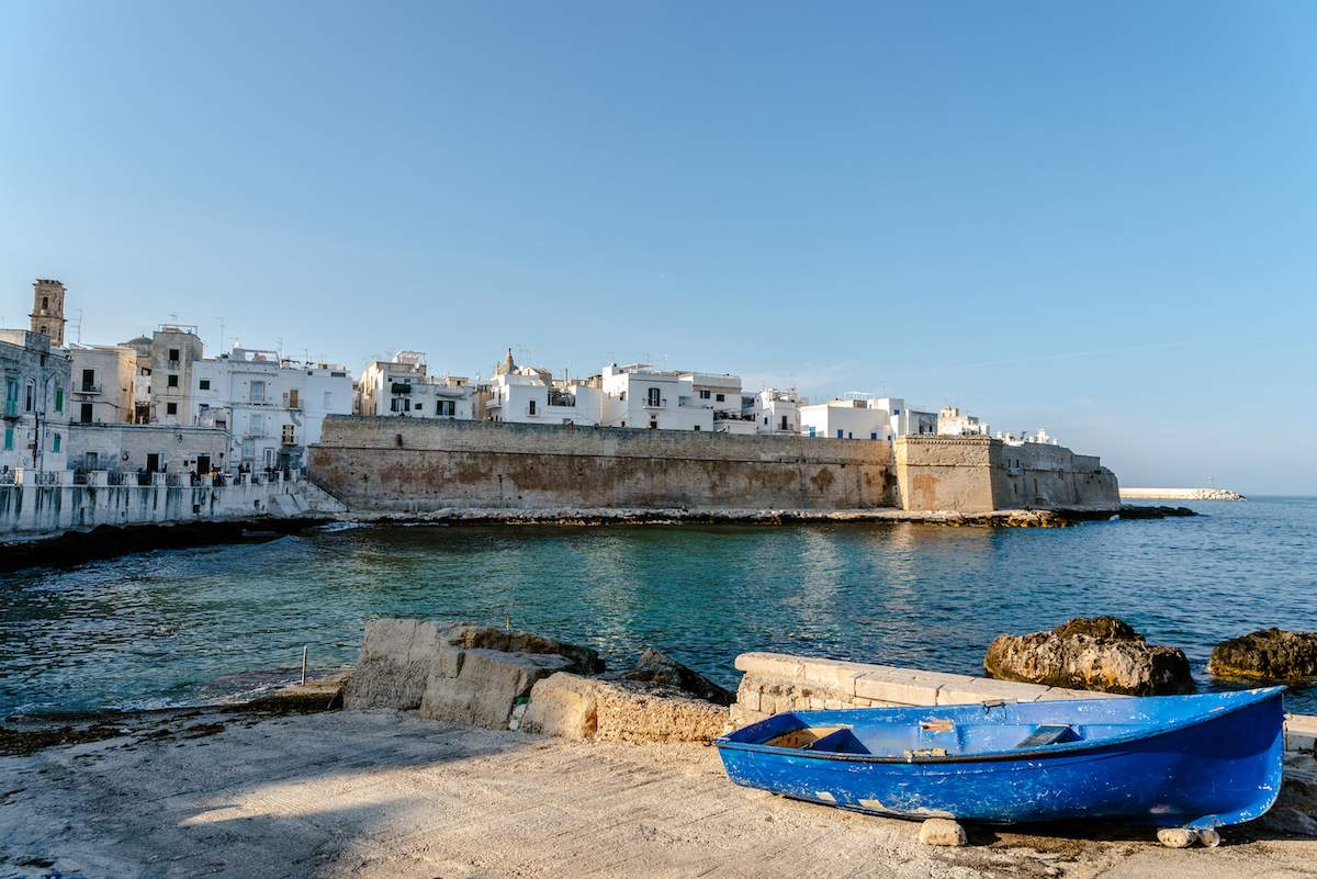 View of the bay of the tourist Italian village of Monopoli, with abandoned skiffs and Bastione di Babula.